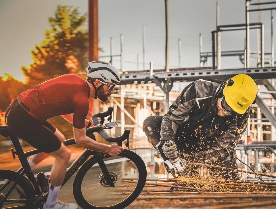 Two images merge: on the left a racing bike rider with the GameChanger 2.0 on his head and on the right a construction site worker wearing the Scator © ABUS